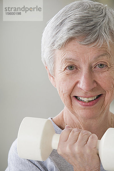 Porträt einer älteren Frau  die mit einem Handgewicht trainiert