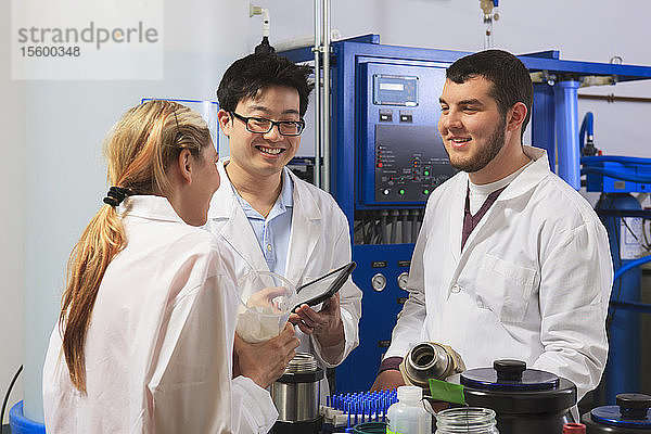 Studenten der Ingenieurwissenschaften untersuchen Flüssigkeitsbehälter und diskutieren in einem Raum mit einem Wasser-Ultra-Reinigungssystem in einem Labor