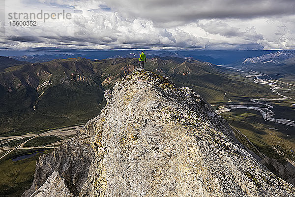 Ein Wanderer stapft vorsichtig über die Klippen in der Nähe des Gipfels des Sukakpak Mountain in der Brooks Range; Alaska  Vereinigte Staaten von Amerika