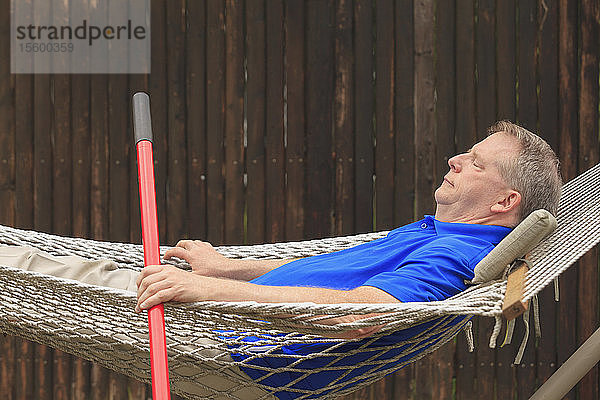 Mann mit zerebraler Lähmung und Legasthenie entspannt sich in seiner Hängematte