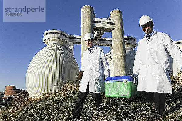 Zwei Wissenschaftler tragen einen Container