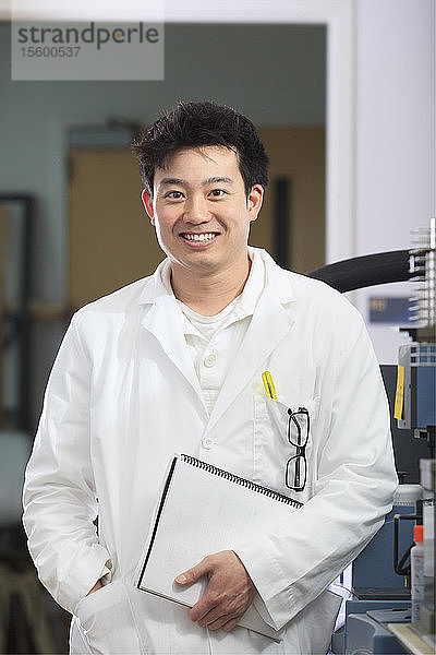 Ingenieurstudent  der ein Benutzerhandbuch für ein chemisches Analysegerät in einem chemischen Analyselabor besitzt