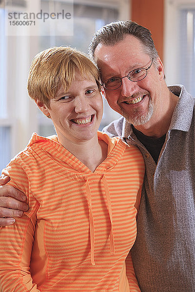 Porträt einer jungen Frau mit Sehbehinderung und ihrem lächelnden Vater