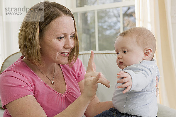 Frau gebärdet den Satz Ich liebe dich in amerikanischer Zeichensprache  während sie mit ihrem Sohn kommuniziert