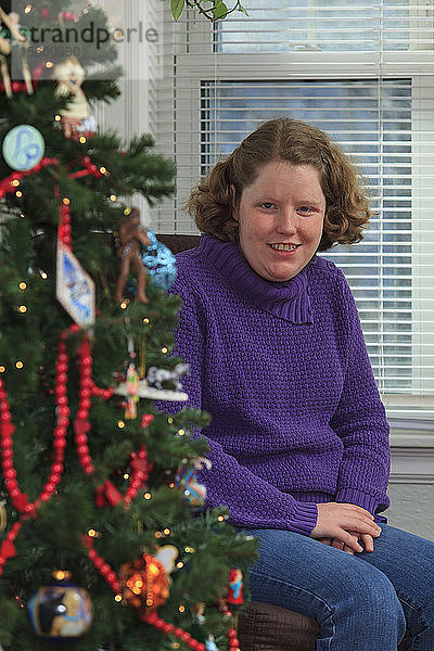 Junge Frau mit Autismus erfreut sich am Weihnachtsbaum
