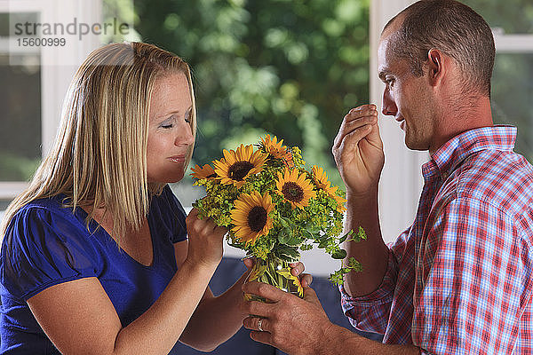 Ein Ehemann  der seiner Frau Blumen schenkt und Flower in amerikanischer Gebärdensprache gebärdet  beide hörgeschädigt