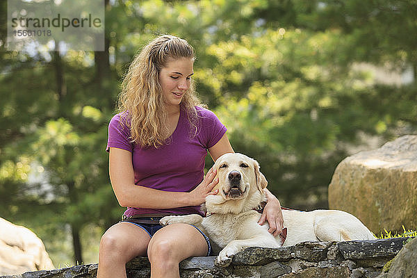 Frau mit Sehbehinderung entspannt sich mit ihrem Diensthund