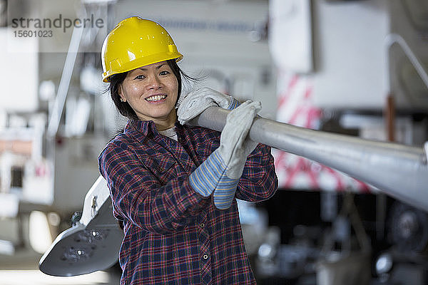 Eine Frau bewegt eine Straßenlaterne in einer Reparaturwerkstatt
