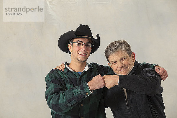 Junger Mann mit Autismus und sein Mentor lächeln und klopfen sich auf die Finger