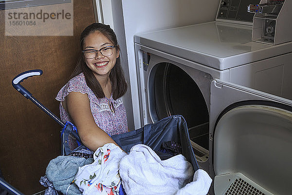 Teenager-Mädchen mit einer Lernbehinderung wäscht Wäsche