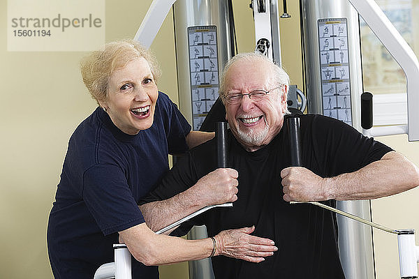 Ein älteres Paar trainiert im Fitnessstudio.