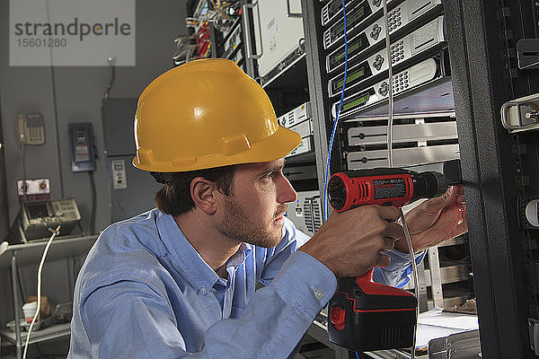 Netzwerktechniker bei der Installation von Kabelgeräten in einem Rack