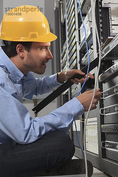 Netzwerktechniker bei der Installation einer Frontplatte in einem Rack
