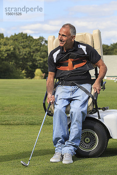 Mann mit Querschnittslähmung in einem adaptiven Wagen zum Golfspielen