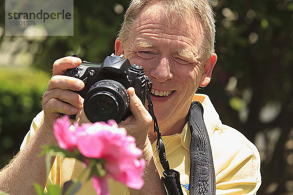 Mann mit zerebraler Lähmung und Legasthenie fotografiert seine Blumen