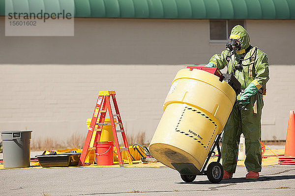 HazMat-Feuerwehrmann beim Schieben eines Bergungsfasses