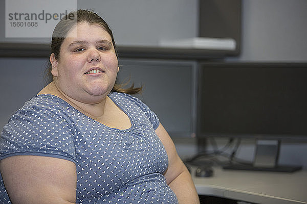 Porträt einer Frau mit einer Lernbehinderung  die in einem Büro arbeitet