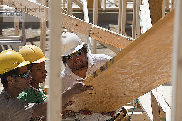 Zimmerleute beim Anheben eines Leimbinders auf einer Baustelle