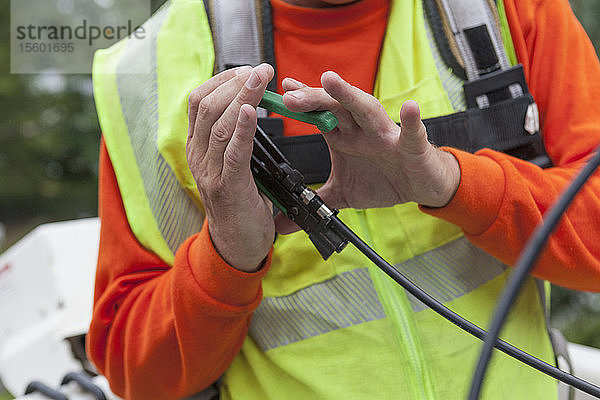 Kabelmonteur beim Anschließen eines Steckers an ein Kabel aus einem Eimerwagen