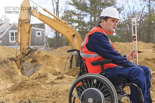 Bauingenieur mit Querschnittslähmung hält auf der Baustelle die Stellung