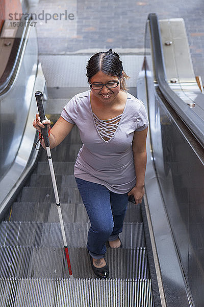 Frau mit Sehbehinderung benutzt den Aufzug