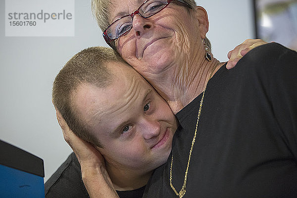 Kellner mit Down-Syndrom  der einen anderen Kollegen umarmt