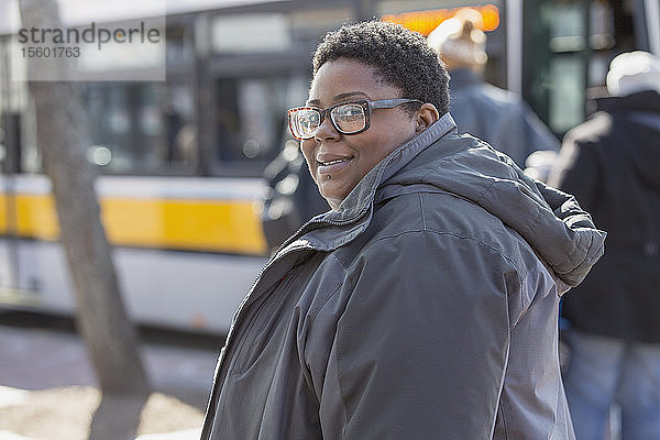 Porträt einer glücklichen Frau mit bipolarer Störung  die einen Bus nehmen will