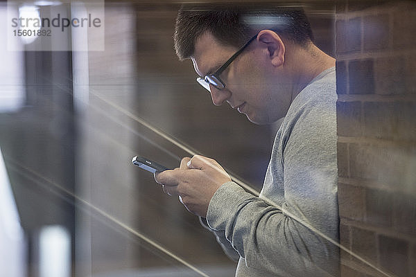 Mann mit Sehbehinderung in der Schule  der sein Handy benutzt