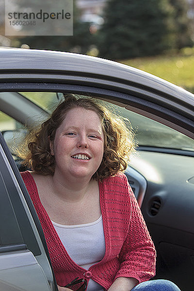 Junge Frau mit Autismus sitzt in ihrem Auto