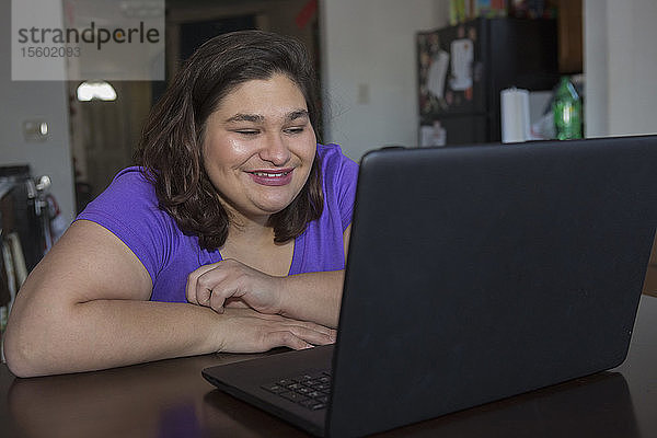 Mädchen mit zerebraler Kinderlähmung am Computer