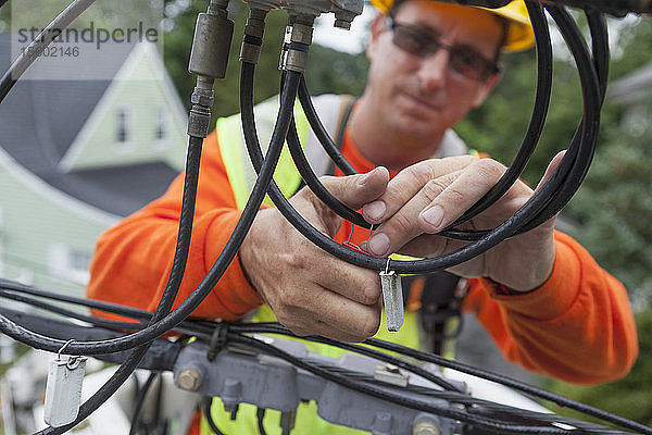 Kabelmonteur beim Anbringen eines Kennzeichnungsschilds am Kabel einer Schaufelbahn