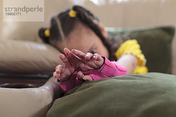 Kleines Mädchen mit zerebraler Lähmung streckt ihre Hände aus