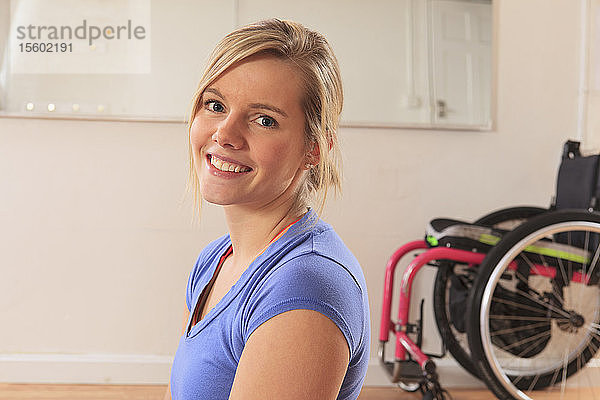 Junge Frau mit einer Rückenmarksverletzung im Rollstuhl in einem Yogastudio