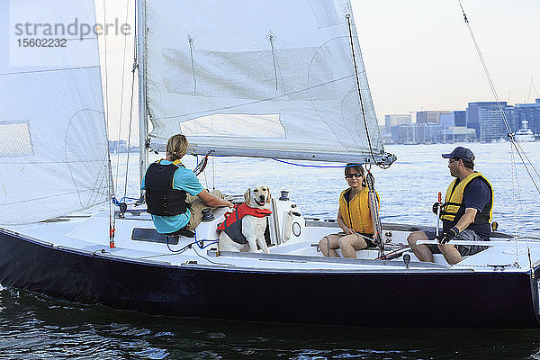 Trainer und Ehepaar mit Sehbehinderung und Diensthund auf einem Boot