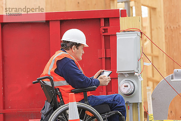 Bauingenieur mit Querschnittslähmung benutzt Tablet  um sich Notizen in einer provisorischen Versorgungsbox zu machen