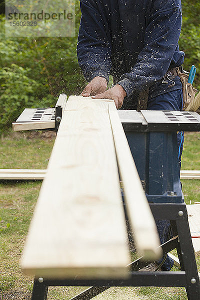 Zimmermann mit Tischsäge auf der Baustelle