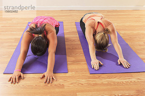 Junge Frauen mit Rückenmarksverletzungen bei Yoga-Posen in einem Studio