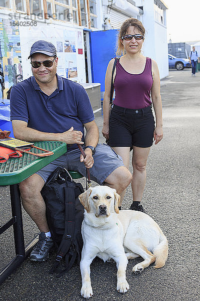 Ein blinder Mann und eine blinde Frau mit einem Diensthund