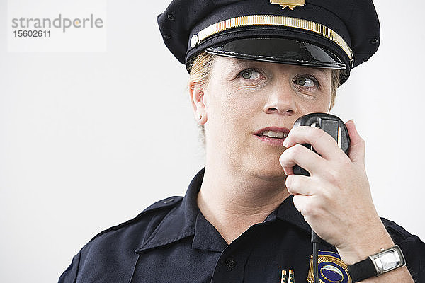 Eine Polizeibeamtin spricht in ein Handmikrofon.