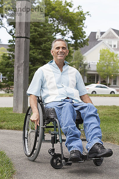 Mann mit Rückenmarksverletzung im Rollstuhl genießt die freie Natur