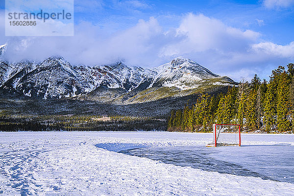 Gefrorener Pyramid Lake mit Eishockeynetz auf einer geräumten Eisfläche im Winter  Jasper National Park; Alberta  Kanada