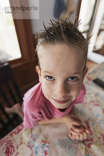 Porträt eines Jungen  der sich auf eine Küchenzeile stützt