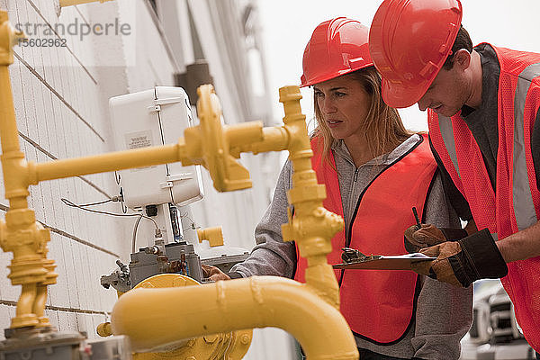 Verfahrenstechniker beim Ablesen von Zählern in der Nähe der Pipeline