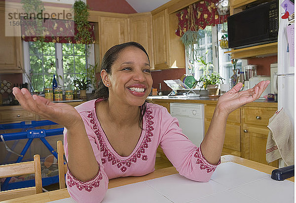 Hispanische Frau lächelnd am Esstisch
