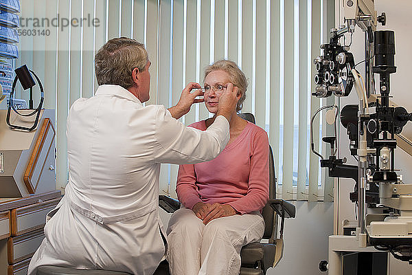 Augenarzt passt die Brille an die Augen einer Frau an