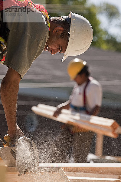 Zimmermann bei der Arbeit mit einer Kreissäge auf einer Baustelle