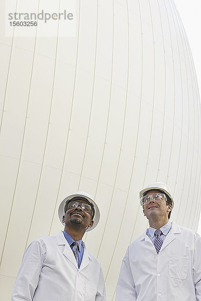 Zwei Wissenschaftler stehen vor einem Faulbehälter
