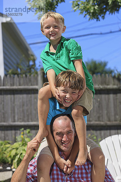 Porträt einer glücklichen Familie mit Hörbehinderung beim Spielen im Hinterhof