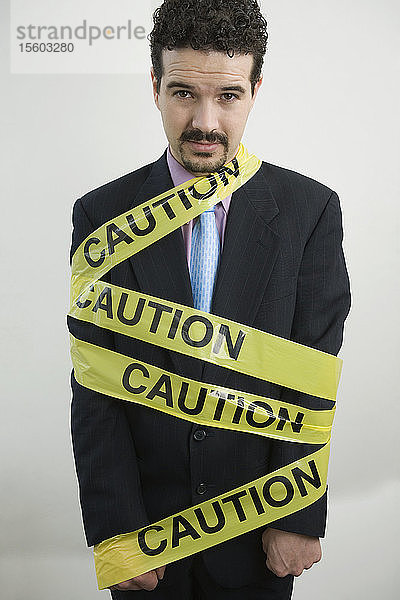 Porträt eines Geschäftsmannes  eingewickelt in ein Warnband