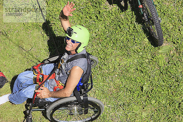 Mann mit Rückenmarksverletzung sitzt im Rollstuhl und bereitet sich aufs Klettern vor